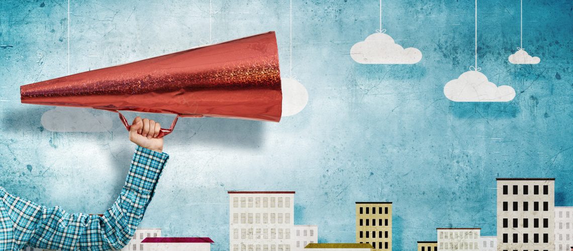 Close of hand holding red paper trumpet