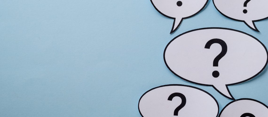 Speech or thought bubbles with question marks forming a side border over a blue background with copy space